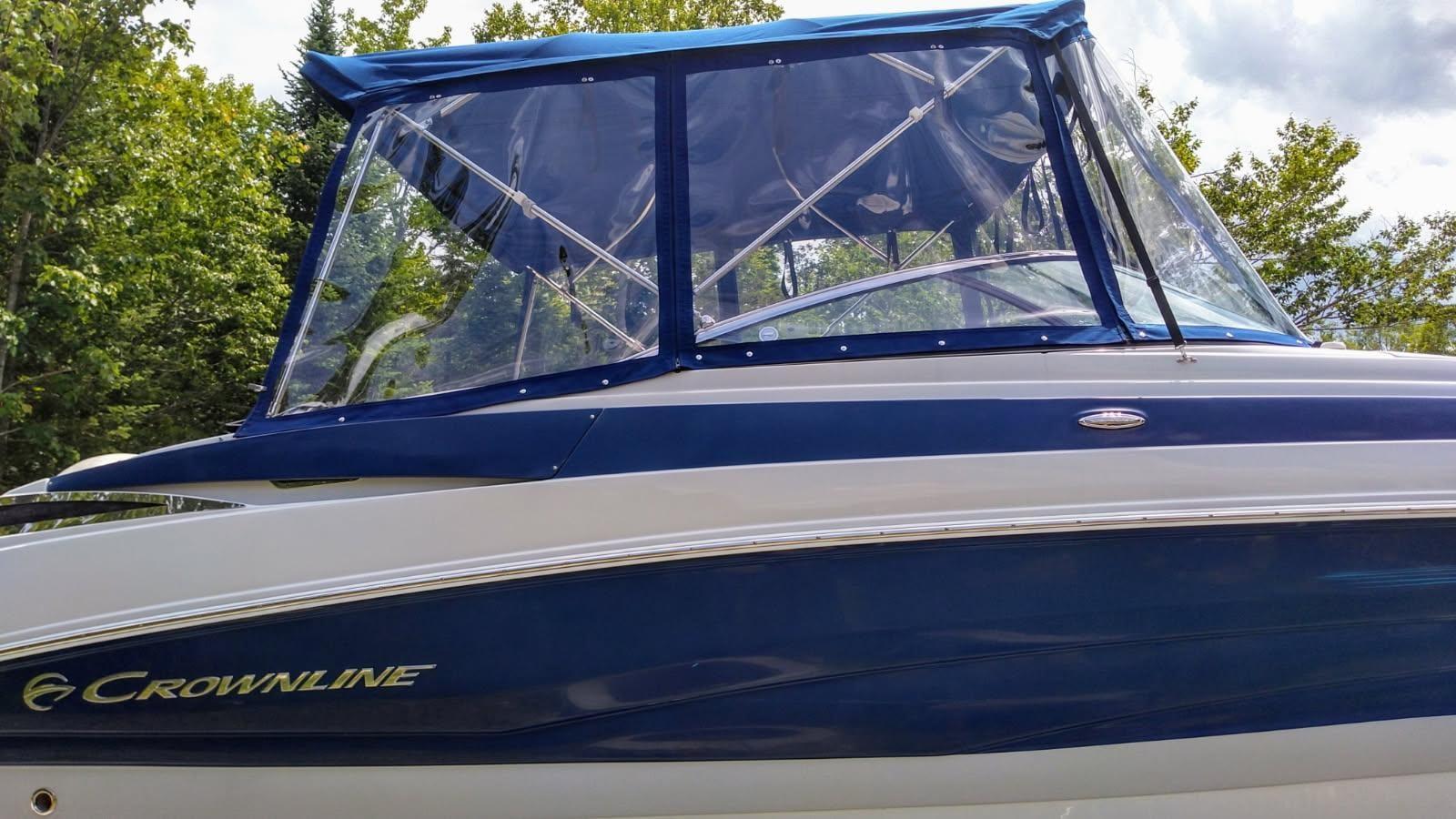 Navy camper enclosure with clear vinyl panels fitted over the cockpit of a Crownline bowrider